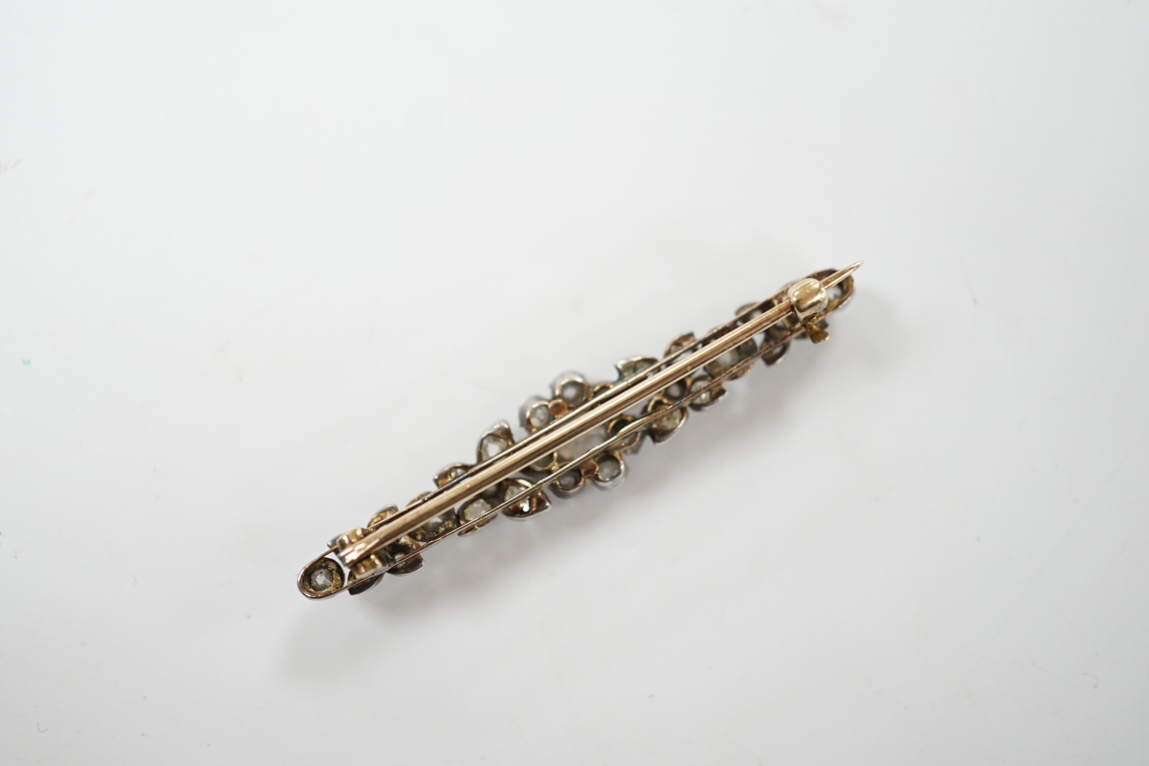 An early 19th century yellow metal and diamond cluster set bar brooch, 47mm, gross weight 4.3 grams. Fair condition.